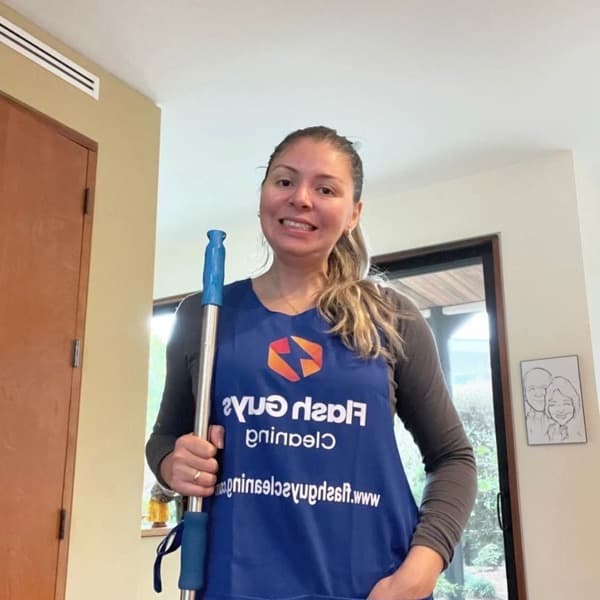 Karolla, co-founder of Flash Guys Cleaning, holding cleaning equipment