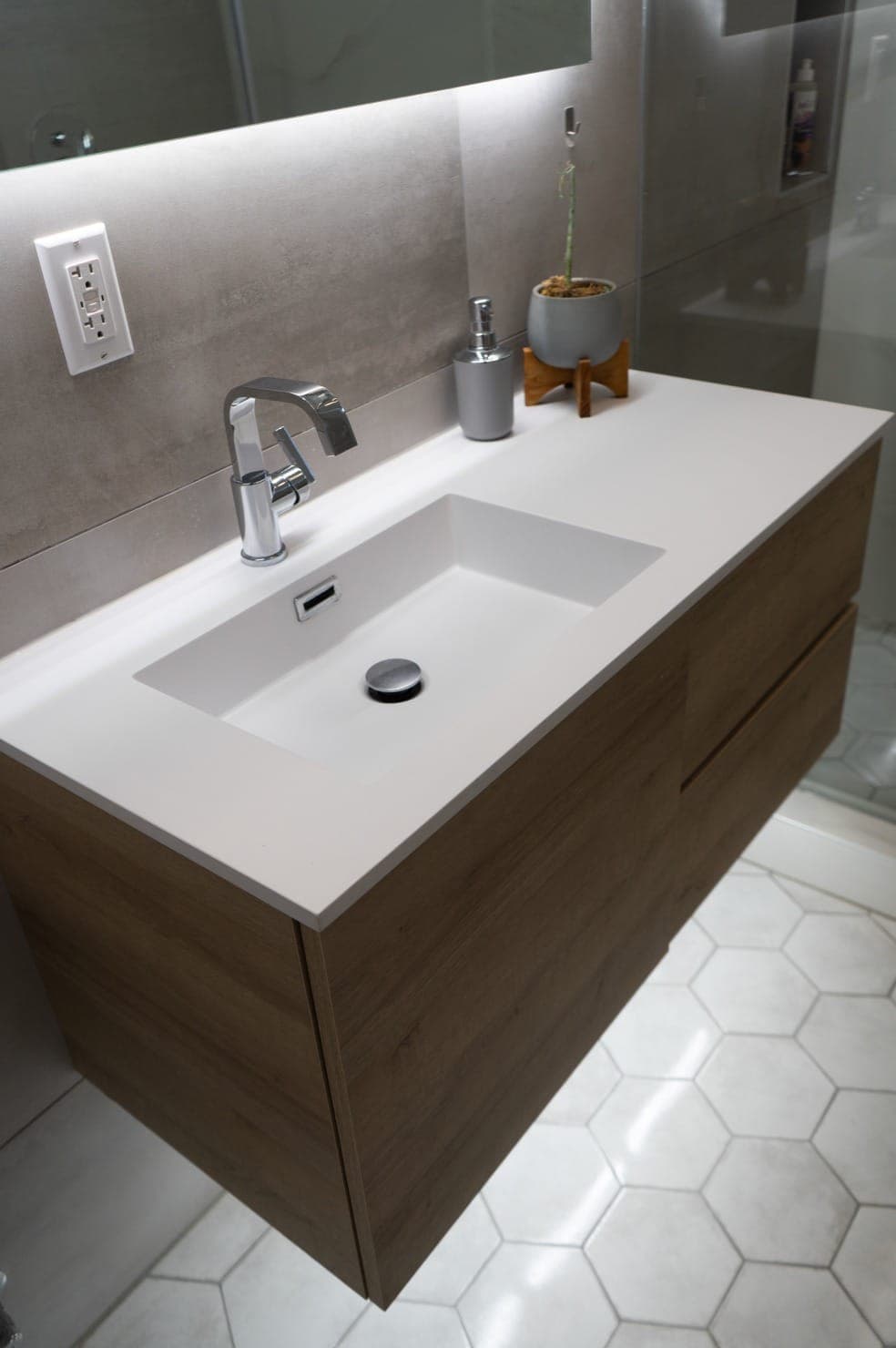 Minimalist bathroom vanity with a clean white sink, modern chrome faucet, and wooden cabinet in a luxury Los Angeles home.