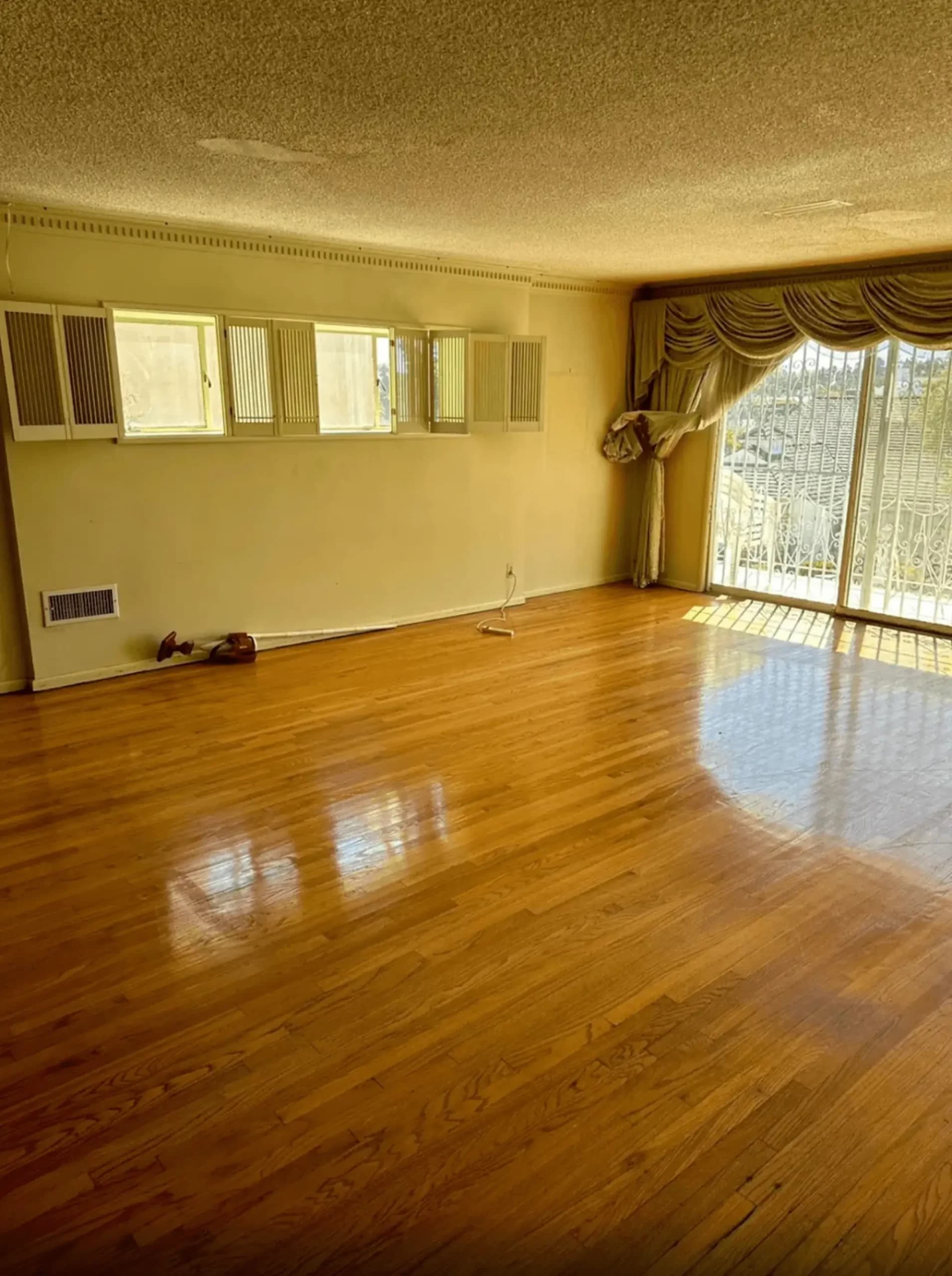 Polished hardwood floor with high-gloss finish in an empty living room with natural light in Los Angeles.
