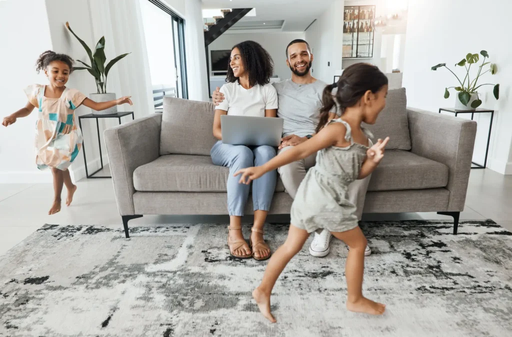Happy family relaxing in a spotless living room after following a 10-minute morning cleaning routine, showing the benefits of a tidy home.
