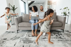 Happy family relaxing in a spotless living room after following a 10-minute morning cleaning routine, showing the benefits of a tidy home.