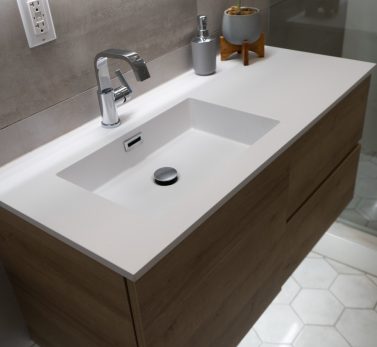 Minimalist bathroom vanity with a clean white sink, modern chrome faucet, and wooden cabinet in a luxury Los Angeles home.